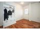 White entryway with wood floors, coat rack, and glass door at 4182 Cordell Ct, Midland, NC 28107