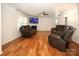 Living room with hardwood floors, two brown leather reclining sofas, and a large TV at 4182 Cordell Ct, Midland, NC 28107