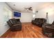 Living room with hardwood floors, two brown leather reclining sofas, and a large TV at 4182 Cordell Ct, Midland, NC 28107