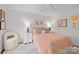 Cozy bedroom with a salmon colored bedspread, white walls and carpet and stylish decor at 4334 Silo Ln, Charlotte, NC 28226