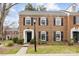 Charming brick townhome featuring a black front door, shutters, and a manicured front lawn at 4334 Silo Ln, Charlotte, NC 28226