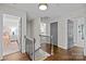 Upstairs hallway with hardwood floors and neutral paint, leading to bedrooms with open doors at 4334 Silo Ln, Charlotte, NC 28226