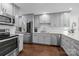 A well-appointed kitchen with stainless appliances, light grey cabinetry, hardwood flooring, and marble countertops at 4334 Silo Ln, Charlotte, NC 28226