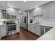 A bright kitchen with stainless appliances, light grey cabinetry, hardwood flooring, and marble countertops at 4334 Silo Ln, Charlotte, NC 28226