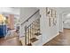 Stylish staircase with patterned runner, wrought iron railing, and artwork on the wall at 4334 Silo Ln, Charlotte, NC 28226