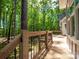 Wooden deck with black metal railing overlooks the peaceful, wooded backyard at 4607 Ferguson Cir, Waxhaw, NC 28173