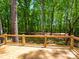 Large wooden deck with black metal railings provides a serene view of the wooded backyard at 4607 Ferguson Cir, Waxhaw, NC 28173