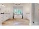 Bright bathroom featuring a soaking tub, double vanities, and wood look tile flooring at 4607 Ferguson Cir, Waxhaw, NC 28173
