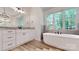Bright bathroom featuring a soaking tub, vanity, and wood look tile flooring at 4607 Ferguson Cir, Waxhaw, NC 28173