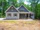 Beautiful craftsman-style home with a stone facade, gabled roof, and covered front porch at 4607 Ferguson Cir, Waxhaw, NC 28173