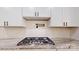 Close up on gas range with custom hood vent, subway tile backsplash, granite countertop, and white cabinetry at 4607 Ferguson Cir, Waxhaw, NC 28173