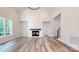 Bright living room featuring hardwood flooring, a fireplace, and large windows for abundant natural light at 4607 Ferguson Cir, Waxhaw, NC 28173