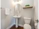 Half bathroom with pedestal sink, wood shelf and oval mirror at 5115 Waterloo Dr, Fort Mill, SC 29708