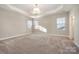 Bright, spacious bedroom featuring a tray ceiling, neutral colors and carpet, and three large windows at 5115 Waterloo Dr, Fort Mill, SC 29708