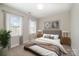 Well-lit bedroom featuring a bed, side tables, framed pictures and a window with curtains at 5115 Waterloo Dr, Fort Mill, SC 29708