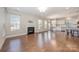 Bright living room with hardwood floors, a fireplace, large windows, and access to the kitchen at 5115 Waterloo Dr, Fort Mill, SC 29708