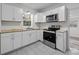 Modern kitchen with white cabinets, butcher block countertops, and stainless steel appliances at 529 Ambassador St, Charlotte, NC 28208