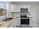 Modern kitchen with white cabinets, butcher block countertops, and stainless steel appliances at 529 Ambassador St, Charlotte, NC 28208