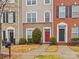 Three-story townhouse with brick and stone exterior, featuring a red front door at 5636 Whitehawk Hill Rd, Mint Hill, NC 28227