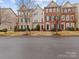 Three-story townhouses with brick and stone exteriors, showcasing a charming streetscape at 5636 Whitehawk Hill Rd, Mint Hill, NC 28227