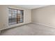 Neutral bedroom showcasing a large window with blinds for natural light and a comfortable carpet at 5818 Harris Grove Ln, Charlotte, NC 28212