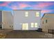 Two story home's backyard view at dusk, showing sliding glass doors and a grassy area at 642 Citriadora St, Fort Mill, SC 29715