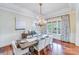 Formal dining room with hardwood floors, chandelier, and large windows at 7213 Fairway Vista Dr, Charlotte, NC 28226