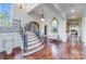 Grand entryway with curved staircase, ornate railing, and hardwood floors at 7213 Fairway Vista Dr, Charlotte, NC 28226