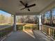 A serene outdoor living space with a covered ceiling and wooden railings overlooking the backyard at 8768 Sherrills Ford Rd, Sherrills Ford, NC 28673