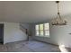 Spacious living room with large windows providing natural light and a decorative chandelier at 8768 Sherrills Ford Rd, Sherrills Ford, NC 28673