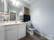 Cozy bathroom with a white vanity, toilet, and decorative wall art and tile flooring at 9635 Veronica Dr, Charlotte, NC 28215