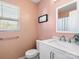 A half bathroom with a single sink and a window for natural light at 1107 Stonehenge Ln, Charlotte, NC 28216