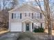 Two-story home with neutral siding, a well-maintained yard, and a single-car garage at 1107 Stonehenge Ln, Charlotte, NC 28216