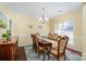 Bright dining room features a spacious table, chandelier, and hardwood floors at 13618 Pacific Echo Dr, Charlotte, NC 28277