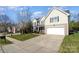 Two-story house with beige siding, a white garage door, and a driveway at 13618 Pacific Echo Dr, Charlotte, NC 28277