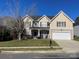 Two-story house with beige siding, a white garage door and landscaping at 13618 Pacific Echo Dr, Charlotte, NC 28277