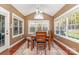 Sunroom with hardwood floors, multiple windows, and a dining table at 13618 Pacific Echo Dr, Charlotte, NC 28277