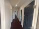 Long hallway with dark hardwood floors and doors to rooms at 1443 Modena St, Gastonia, NC 28054