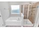 A luxurious bathroom featuring a garden tub and a separate glass-enclosed shower at 14812 Baytown Ct, Huntersville, NC 28078