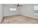 A well-lit bedroom featuring carpeted floors, large windows, and a modern ceiling fan at 14812 Baytown Ct, Huntersville, NC 28078