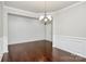 Inviting dining room featuring elegant wainscoting, a modern chandelier, and hardwood flooring at 14812 Baytown Ct, Huntersville, NC 28078