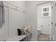 Clean bathroom with bench and coat hooks, next to a toilet and small window at 2025 Tom Sadler Rd, Charlotte, NC 28214