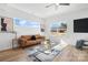 Bright living room with hardwood floors, a brown leather couch, and large windows at 2041 Greenoak Dr, Shelby, NC 28152