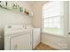 Bright laundry room with washer, dryer, and overhead shelving at 2131 Ashley Glen Way, Indian Land, SC 29707