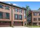 Three story brick townhome with dark brown garage doors and shutters at 2549 Vail Ave, Charlotte, NC 28207