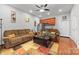 Cozy living room with ceiling fan, warm colors, kitchenette, and comfortable brown sofa and loveseat at 2865 Scarborough Ct, Gastonia, NC 28054