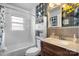 Bright bathroom features a shower-tub combo, tiled walls, and a modern vanity with decorative mirror and cabinet at 2907 1St Nw Ave, Hickory, NC 28601