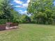 Expansive green backyard with mature trees, and a cozy deck perfect for outdoor relaxation at 3021 Botany St, Charlotte, NC 28216