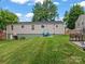 Spacious backyard featuring a well-maintained lawn, wooden fence, and charming outdoor seating area at 3021 Botany St, Charlotte, NC 28216