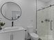 Modern bathroom featuring white cabinets, a round mirror, toilet, and glass shower with marble tiling at 3021 Botany St, Charlotte, NC 28216